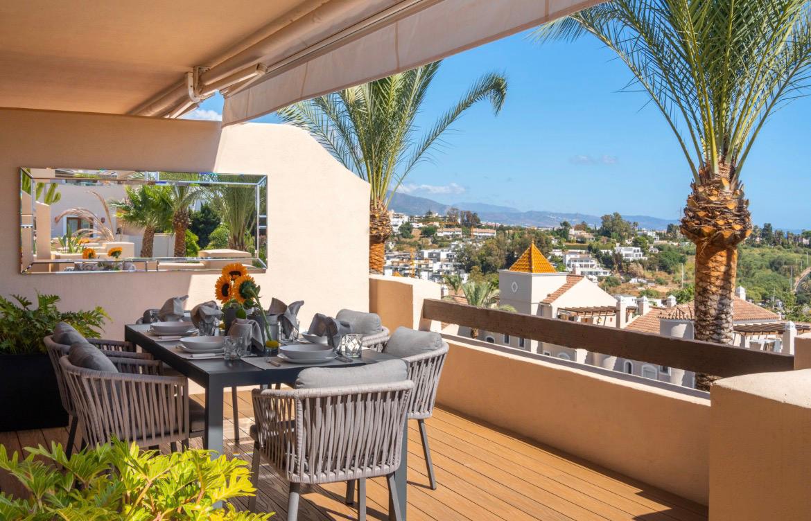 Sunset terrace dining with palms and mountain backdrop